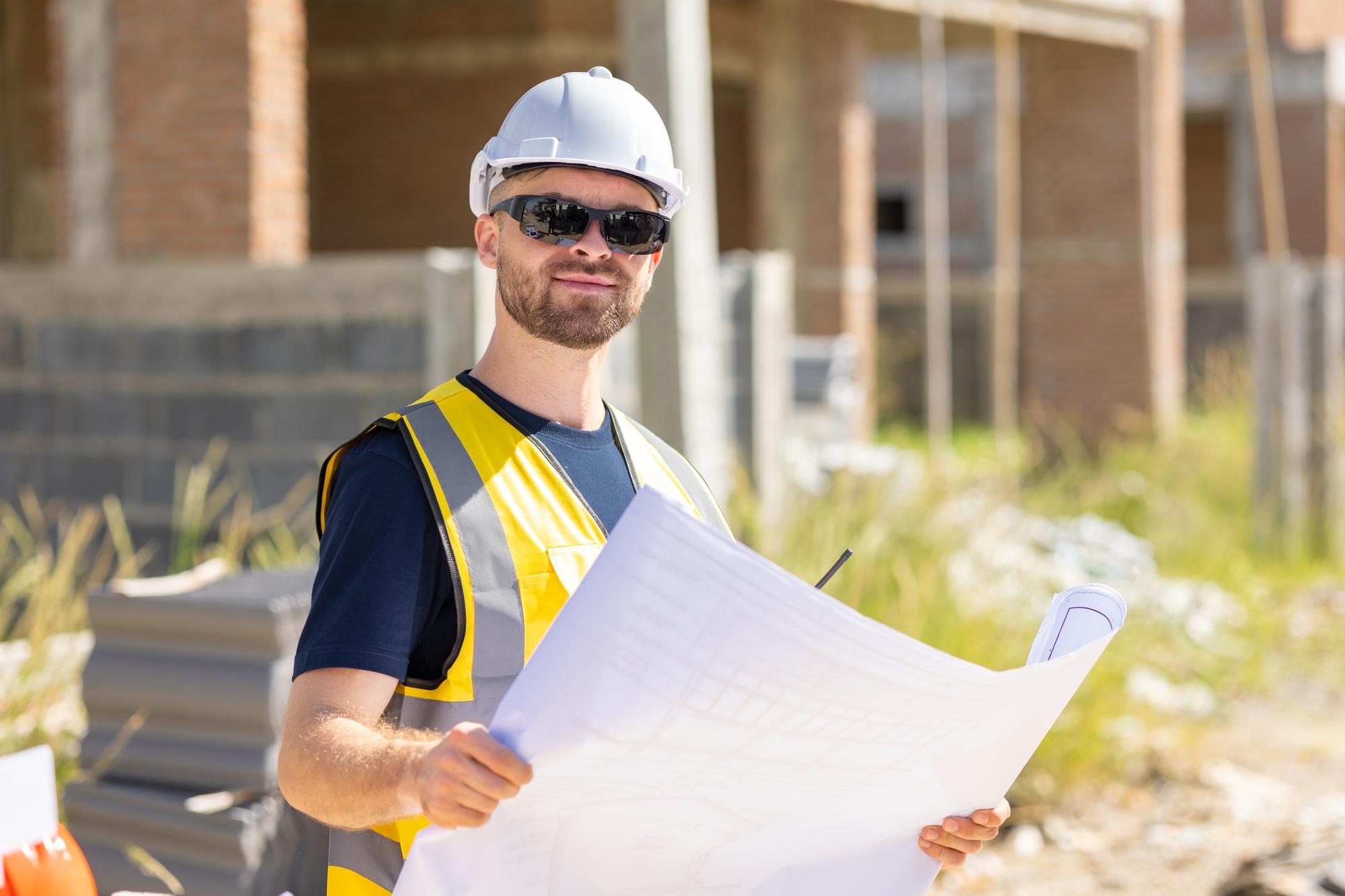 Il project manager con il cronoprogramma in mano davanti a un cantiere