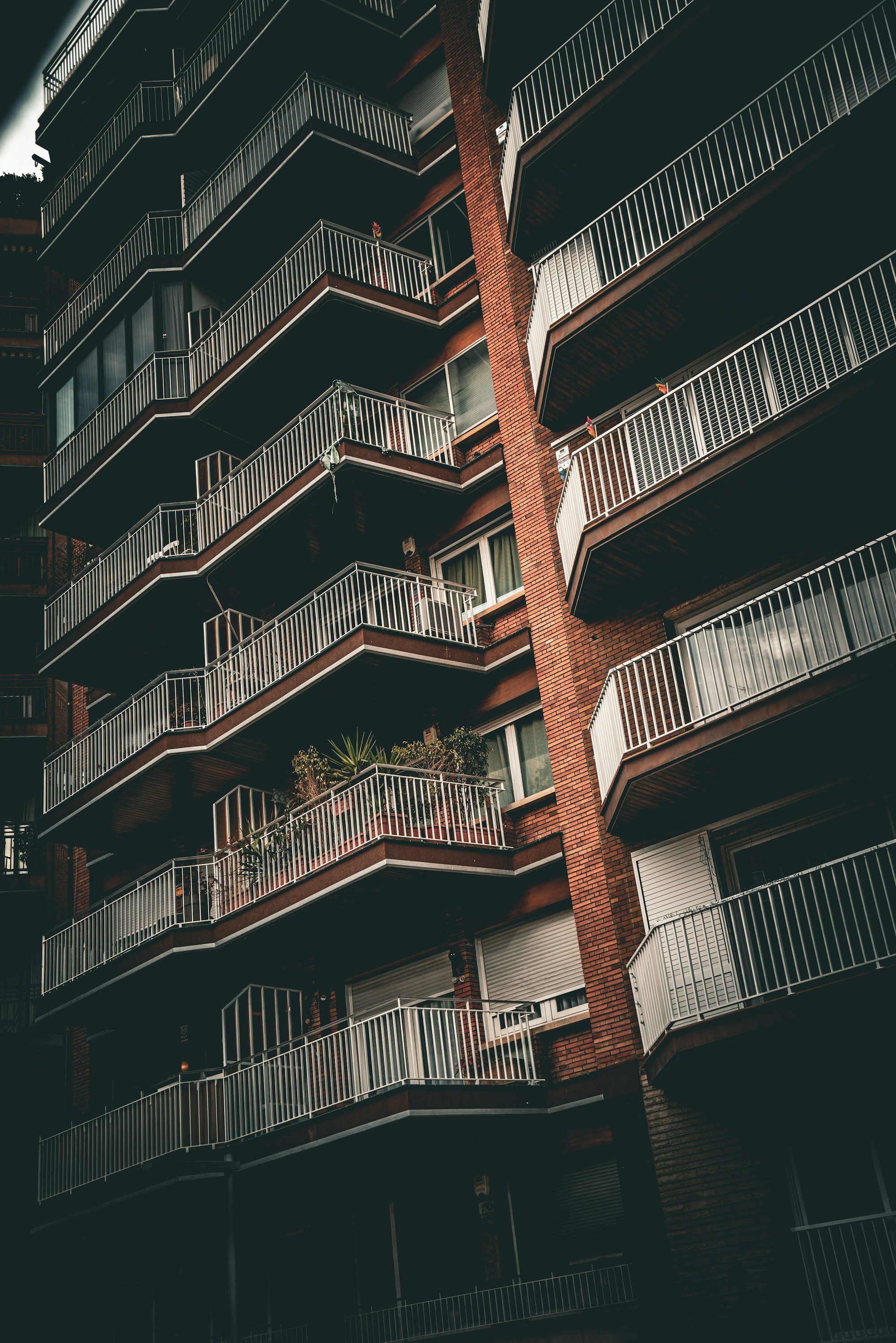 Facciata di un condominio con balconi e ringhiere, in ombra