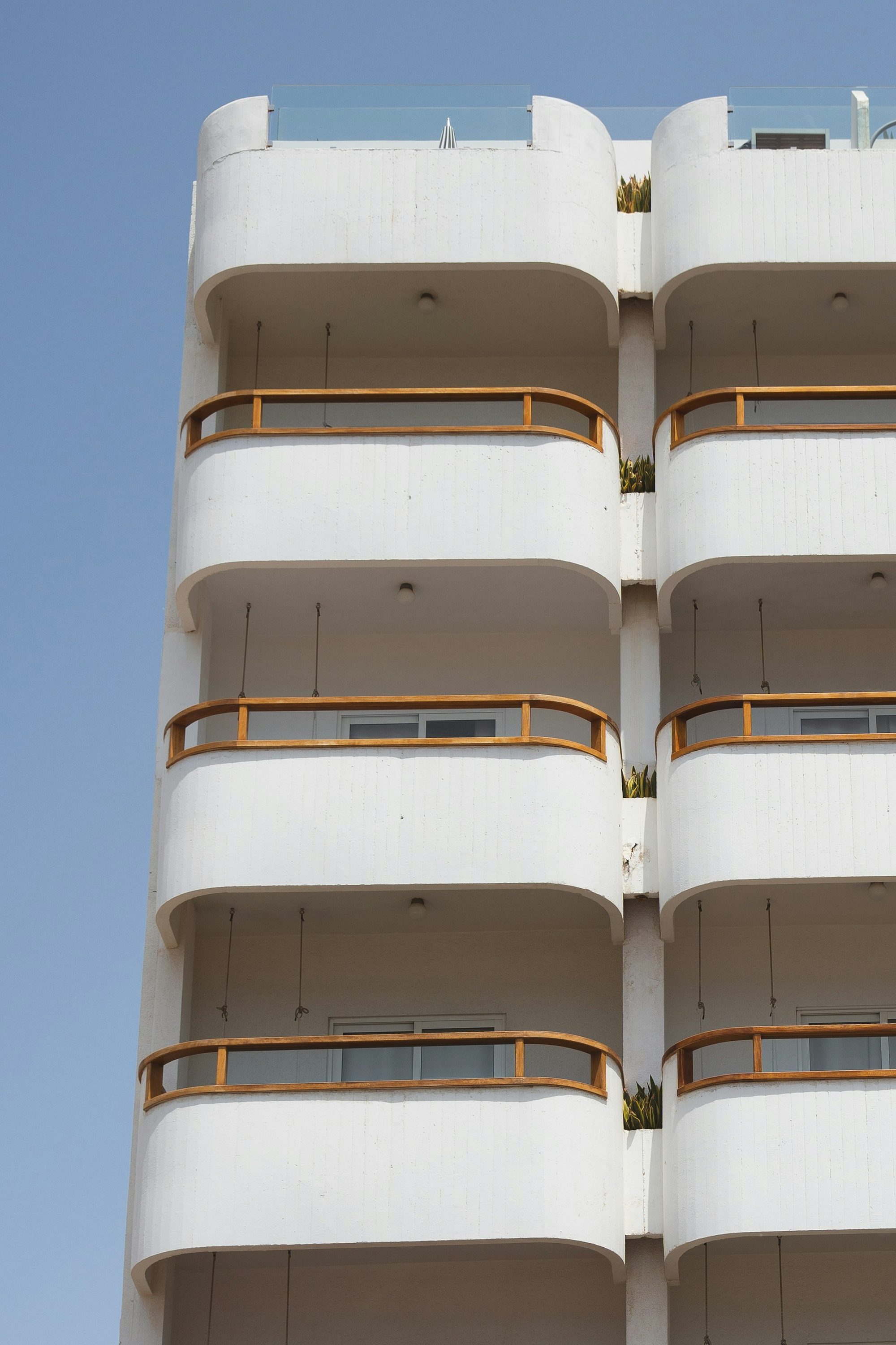 Facciata chiara di un edificio con balconi curvi contro il cielo